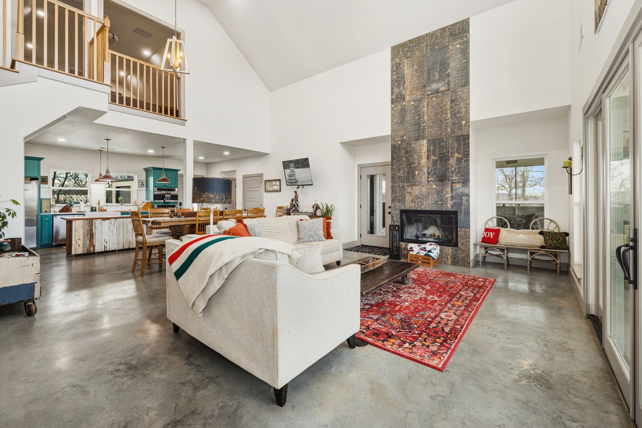 Our great room is complete with living and dining areas, high ceilings, large windows, comfy seating, and a large Smart TV. 