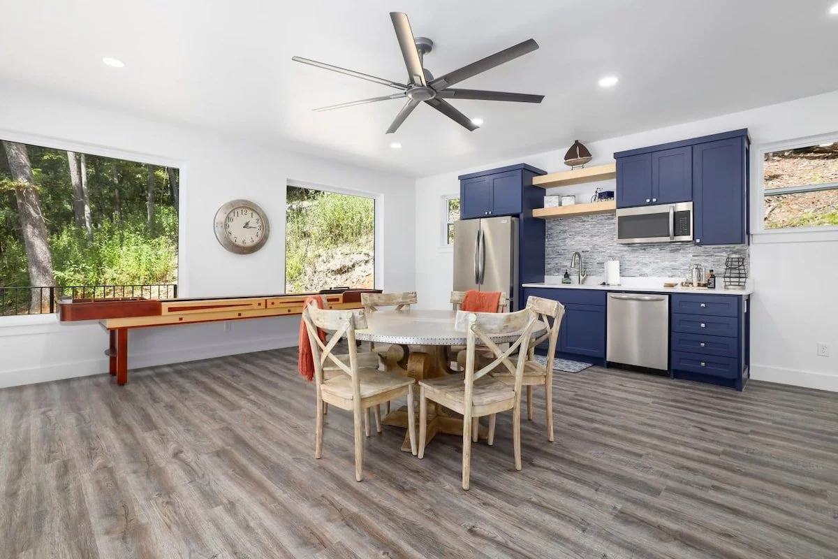 The game room has a kitchenette, a 65-inch Smart TV, a shuffleboard table, and plenty of board games.