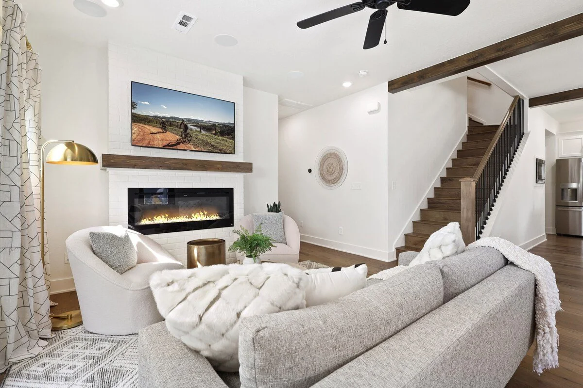 Here, you'll find an overstuffed gray couch, two lounge chairs, a 55-inch TCL Roku TV and our stunning electric fireplace. 
