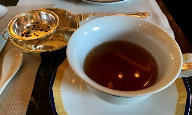 Tea strainer, tea strainer holder, cup of tea.