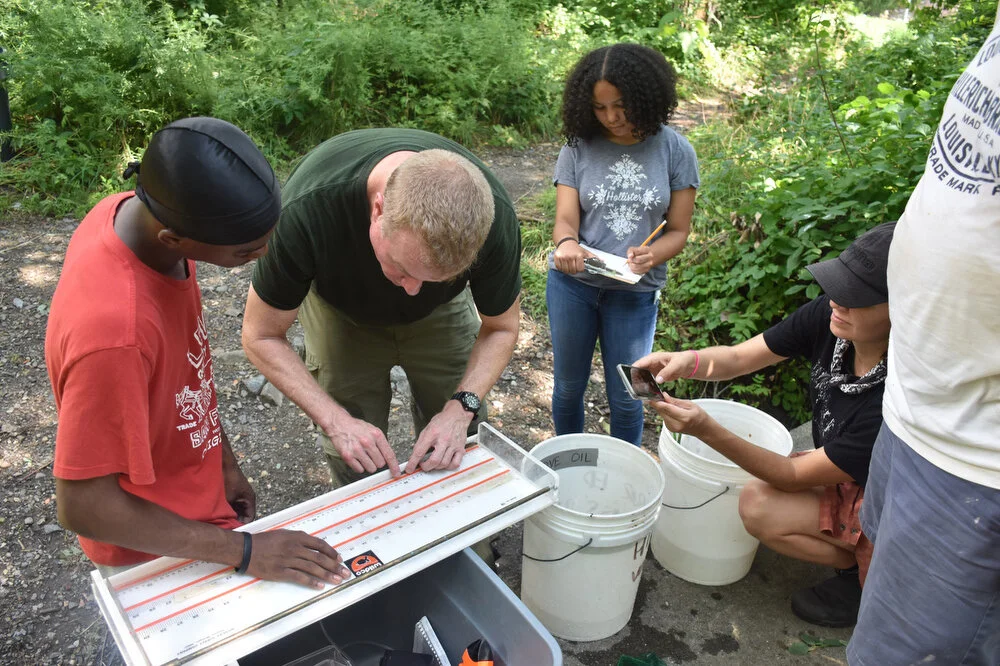  Kai Griffin, left, assists DEC research Chris Bowser, center left, in measuring American eels while Nicolena Russell, center right, records the data on the shore of the Poesten Kill in Troy, N.Y. on Aug. 8, 2018. 
