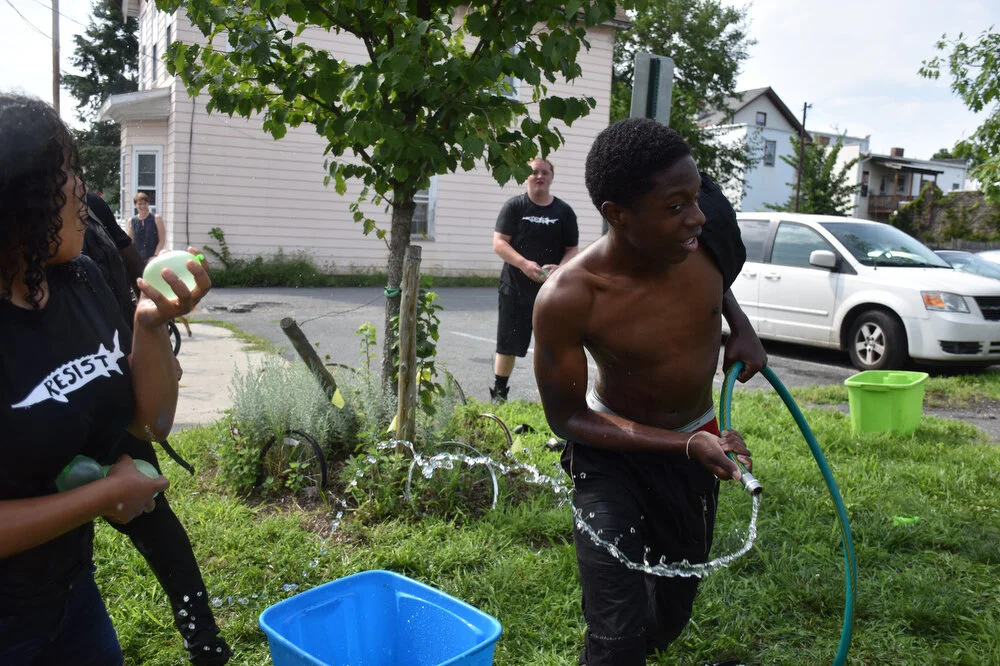  Jarelle Summers, center, swings a hose towards his fellow youth employees to celebrate the last day of the Uptown Summer program in Troy, N.Y. on Aug. 10, 2018. 