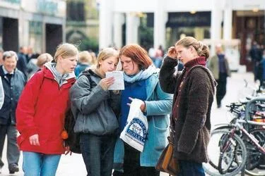 20_young_tourists_consult_paper.jpg