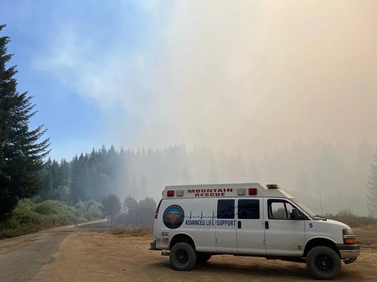 Looking back at the summer,  our ambulance on the fire line, surrounded by smoke, our paramedics and EMTs standing ready.

#FireLine
#FirstResponders
#Paramedics
#WildfireResponse
#ServingOurCommunity