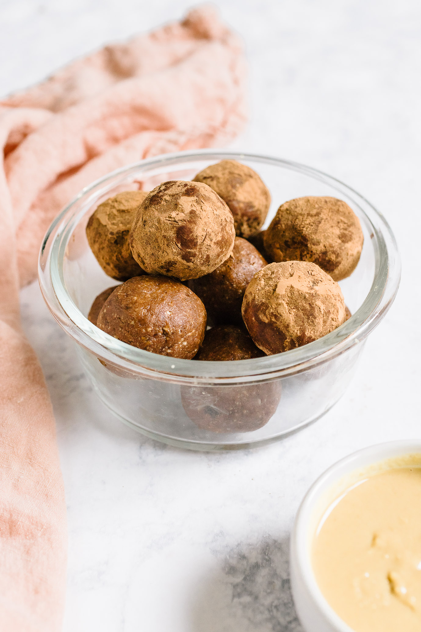 cacao tahini snack bites in glass bowl with pink napkin