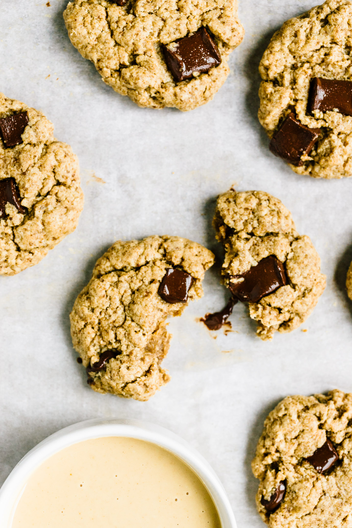 split chocolate chip tahini cookie on parchment paper