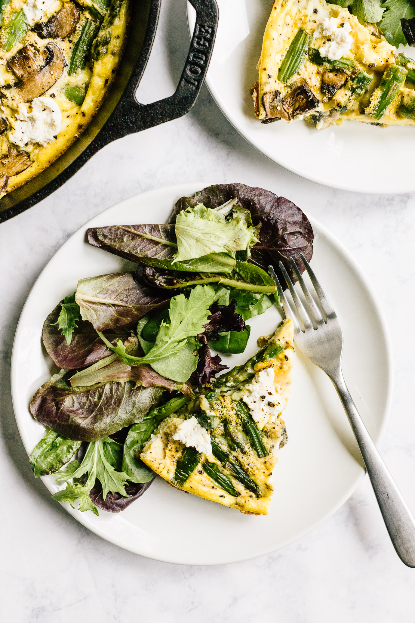 Slice of asparagus mushroom frittata with green side salad