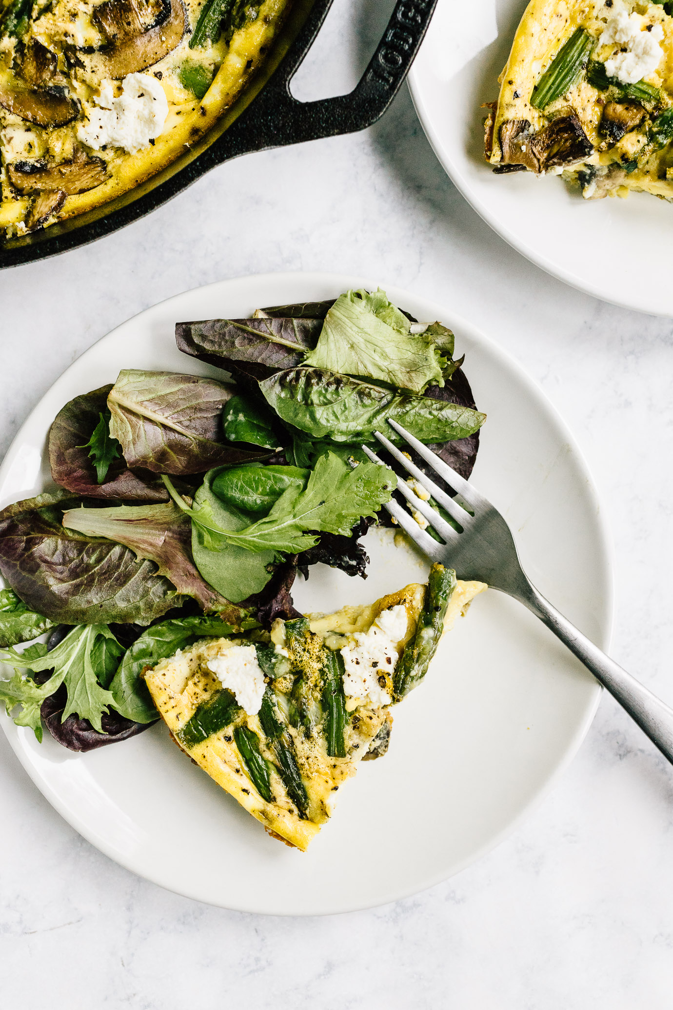 Slice of asparagus mushroom frittata with green side salad