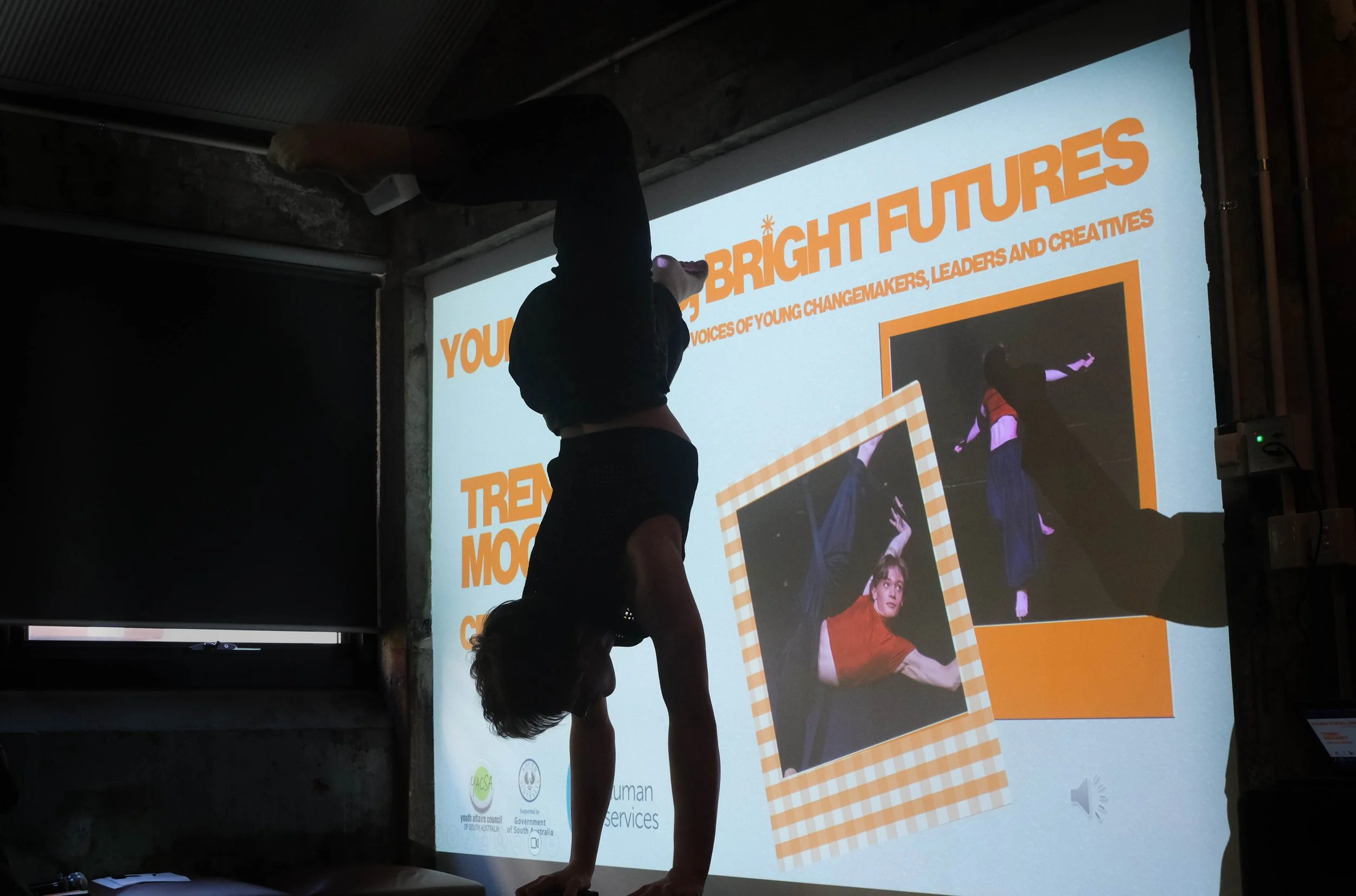 Trent is in a handstand on handstand stilts with one leg angles in front of him and the other behind