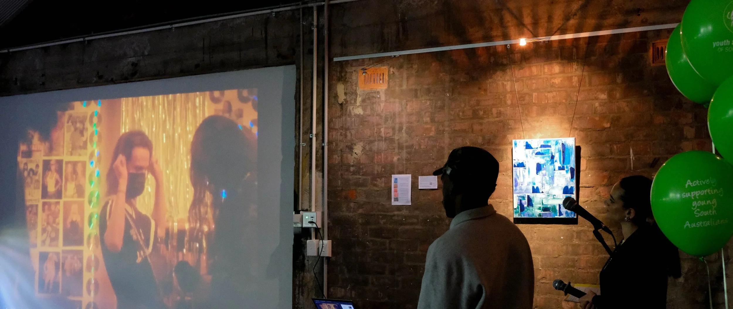 Shabani watches video playing from projector screen