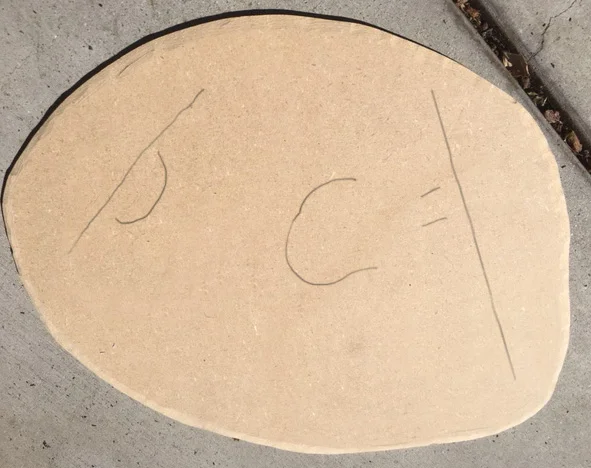 A cut and sanded base, with the pencil markings for where the ship would be placed.