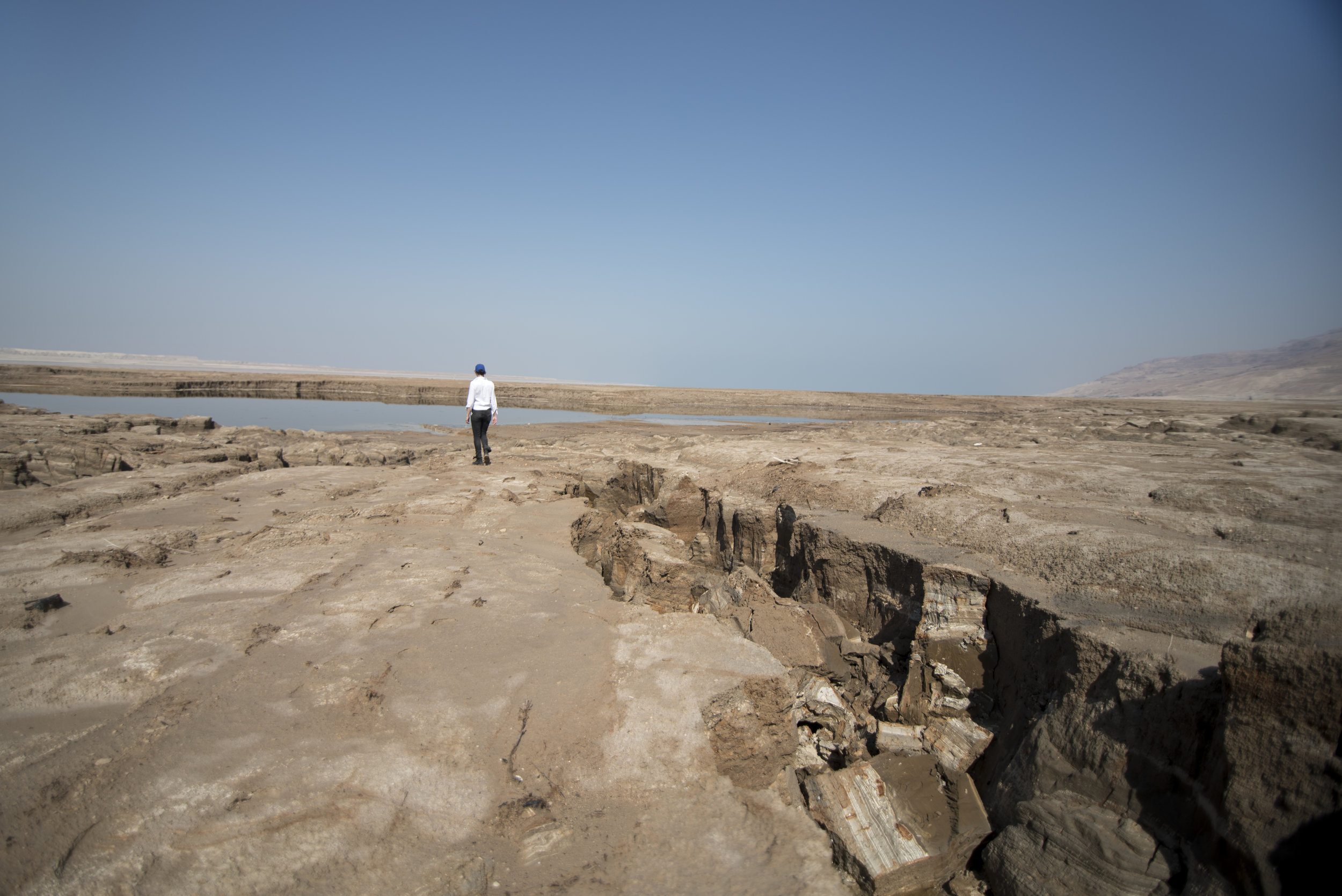 Cracks and mile-wide sinkholes still partially filled with water dot the landscape where once the Dead Sea used to be.