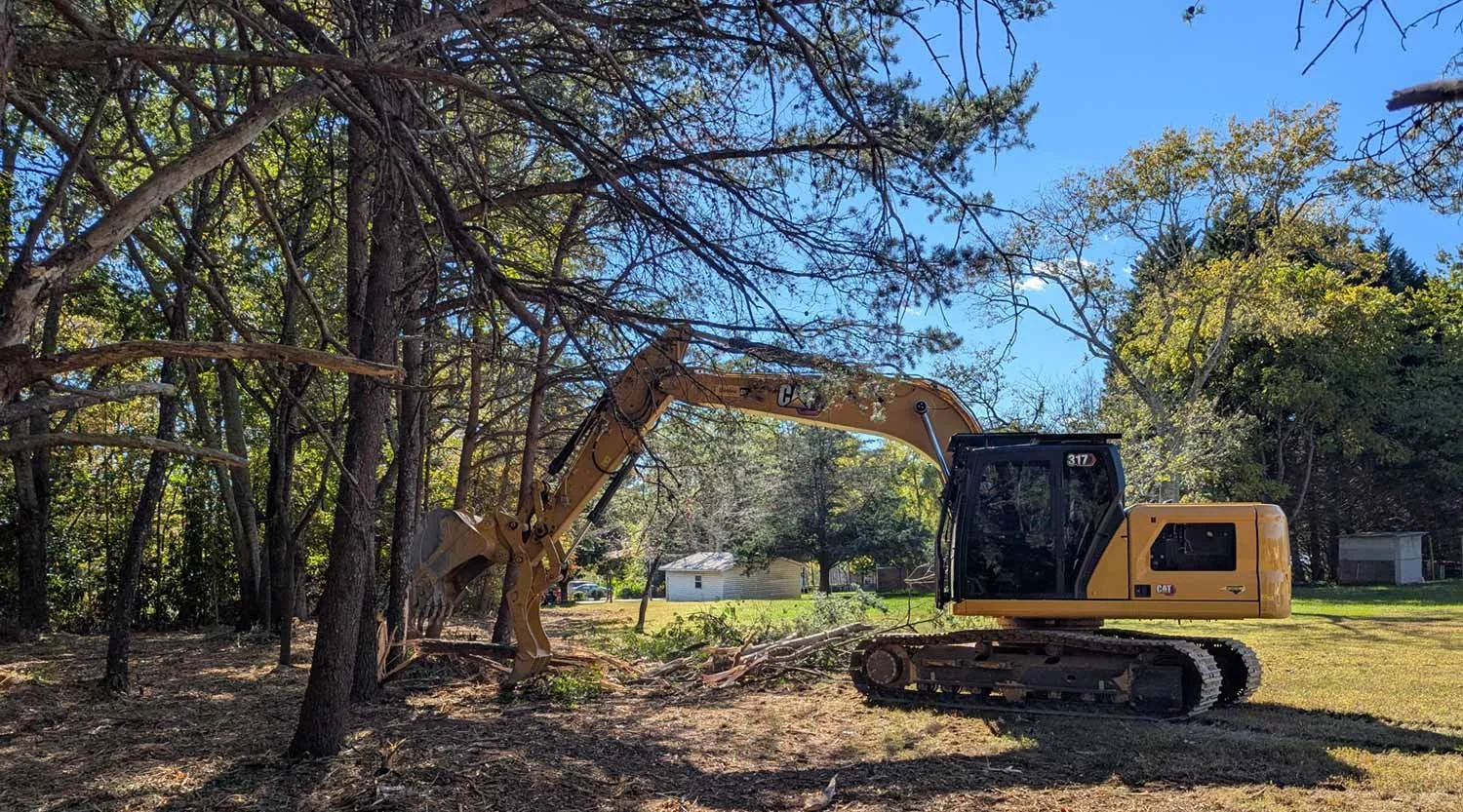 Excavator clearing lot for new building in Hudson, NC