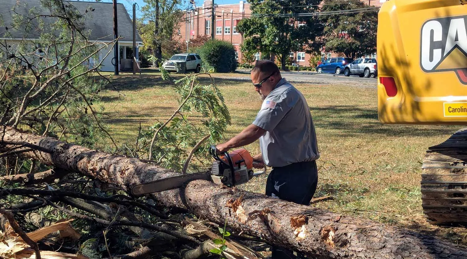 Chad Cannon, owner of Appalachian Excavating & Grading, using a chainsaw