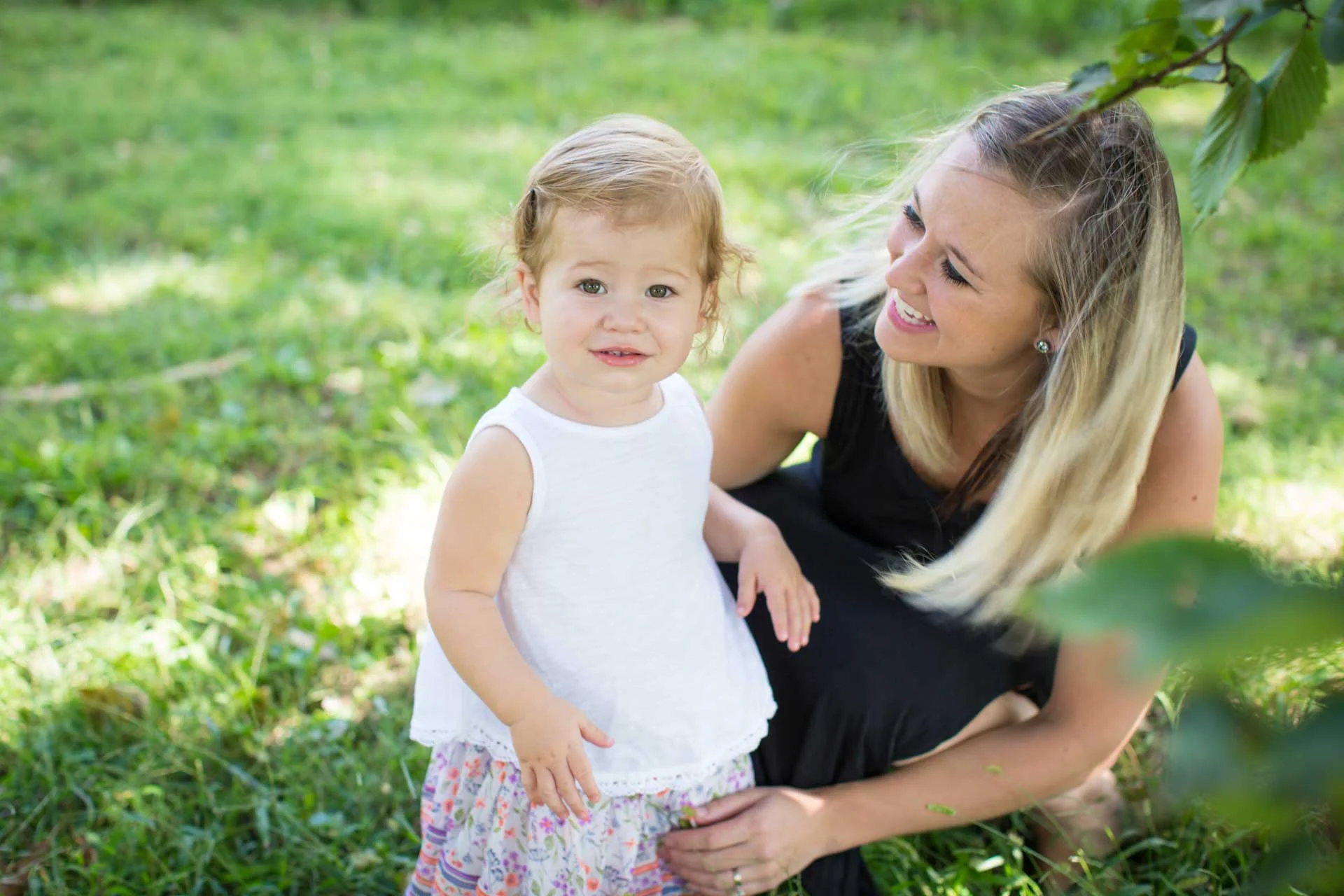 little-girl-looking-at-the-camera-curiously-outside-with-her-nanny.jpg