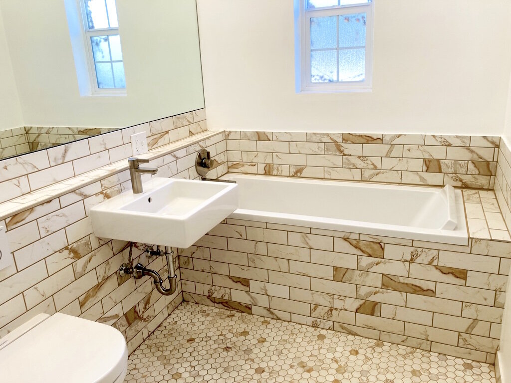 Mirror, shower enclosure and fixtures are installed.