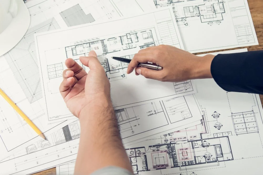 Interior design professionals reviewing architectural floor plans before a renovation