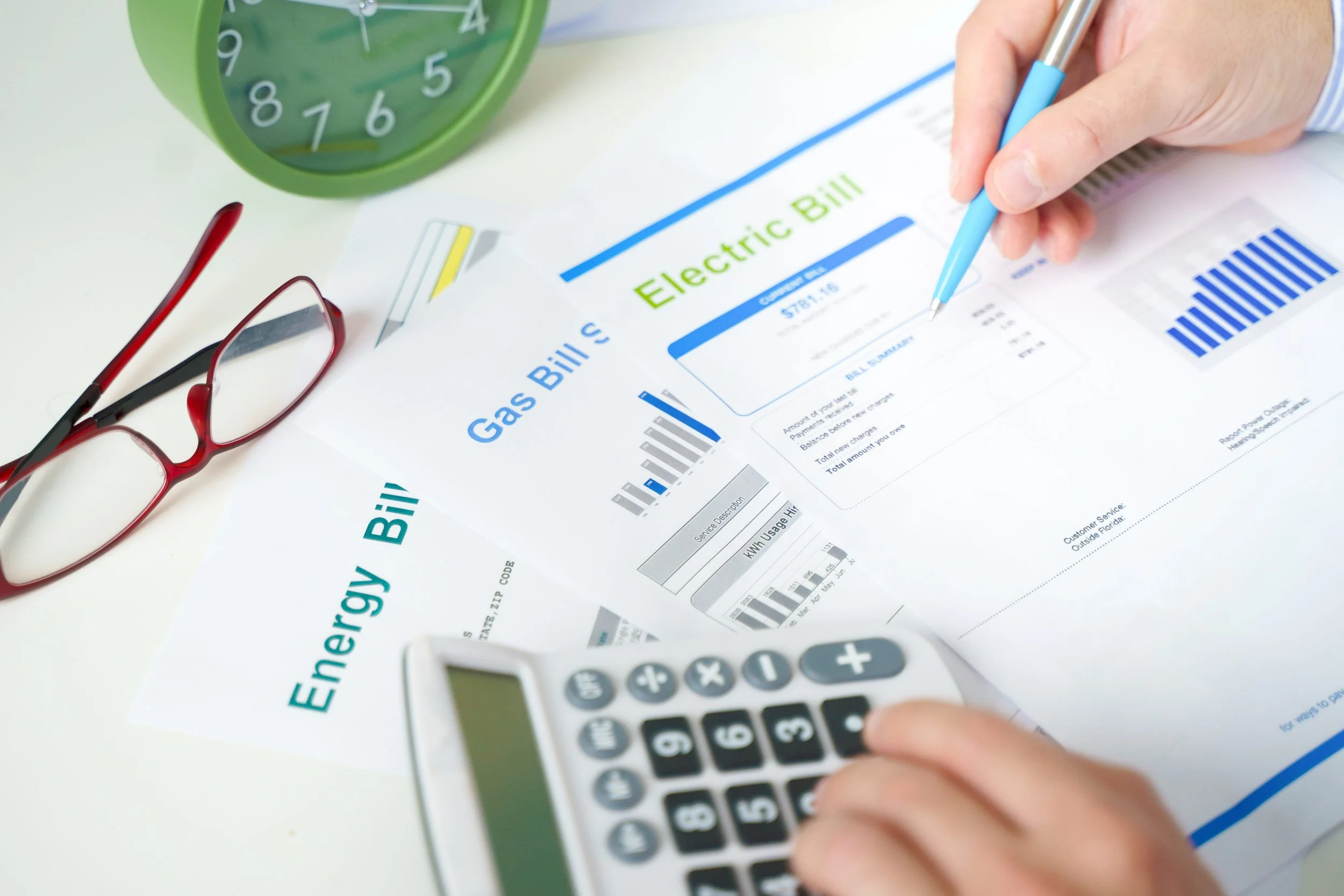 Homeowner reviewing gas, electric and energy bills with a calculator