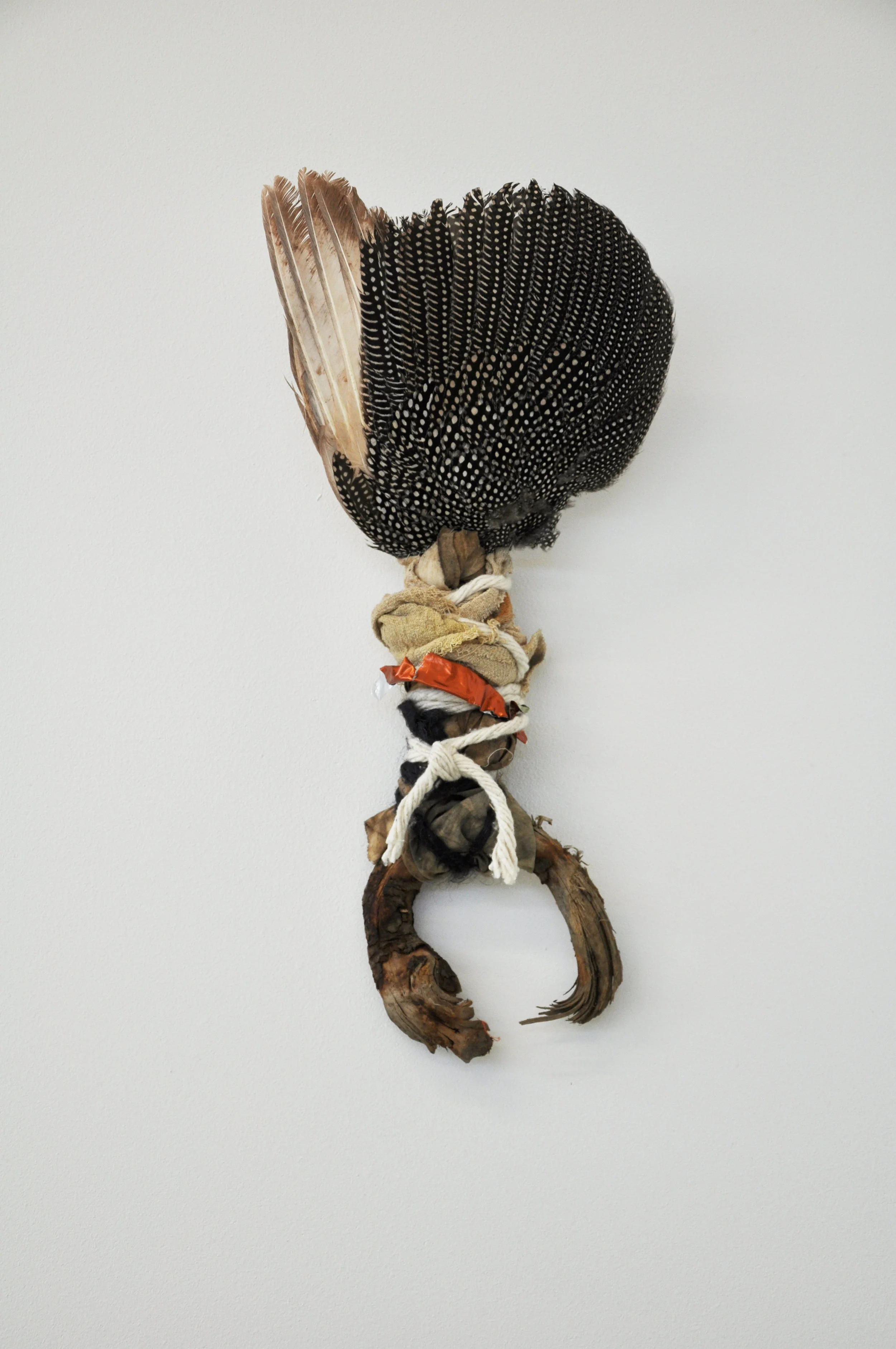 Praise Be, 2018 guinea fowl wing, wood, cloth, string, foil h55cm 