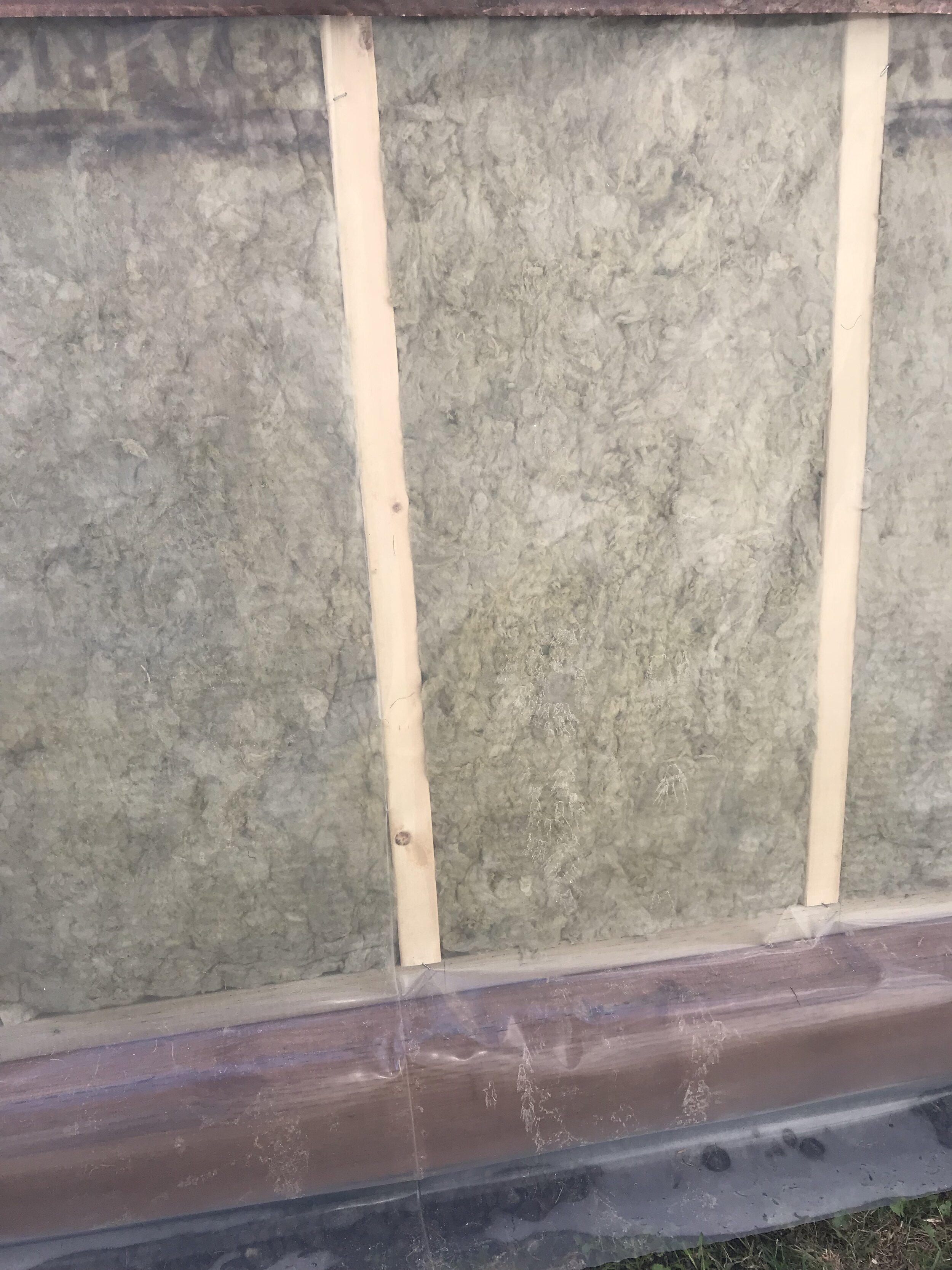 Vapour barrier covers treated foundation wood to prevent chemical leaching into growing bed 