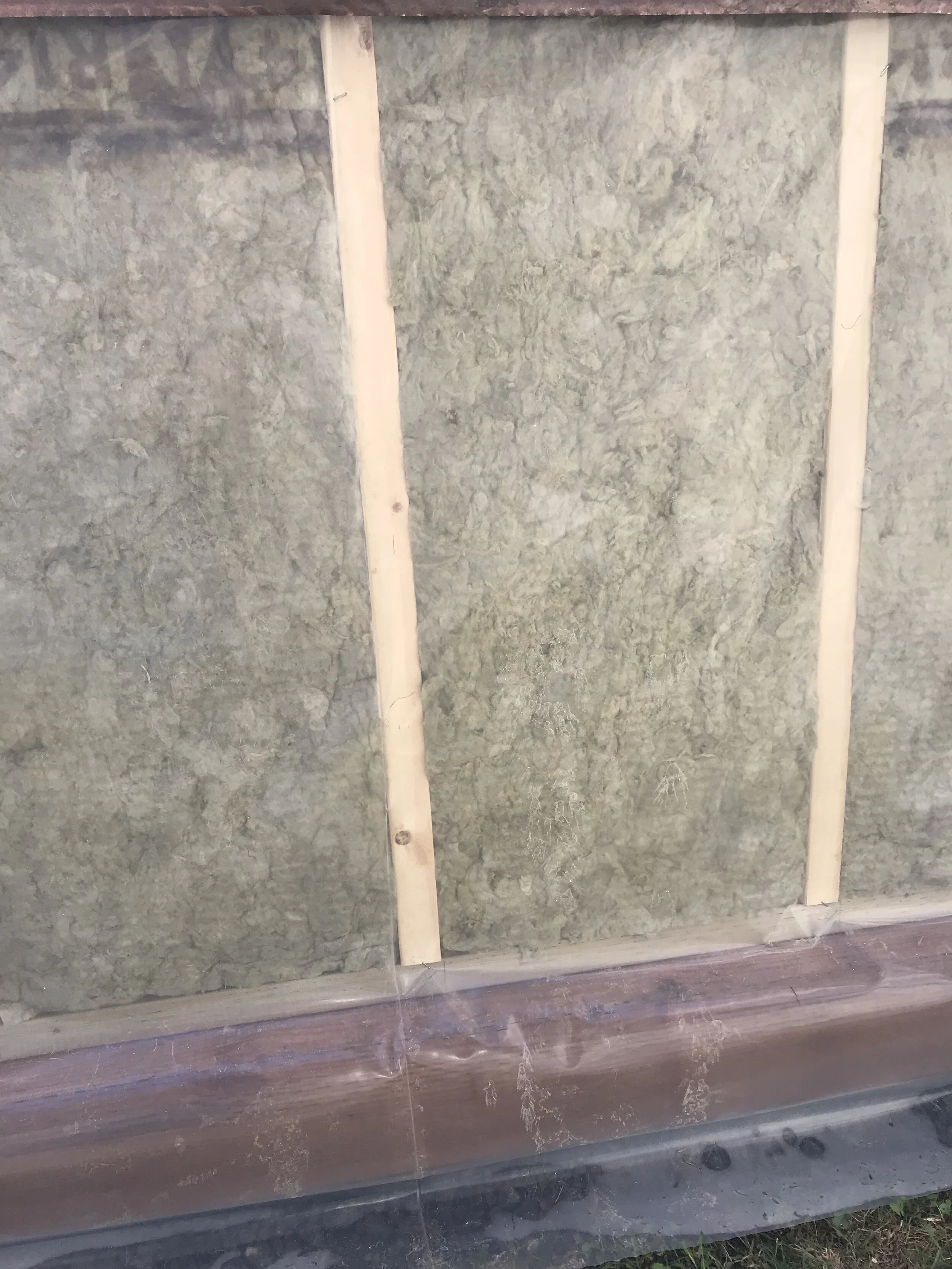 Vapour barrier covers treated foundation wood to prevent chemical leaching into growing bed