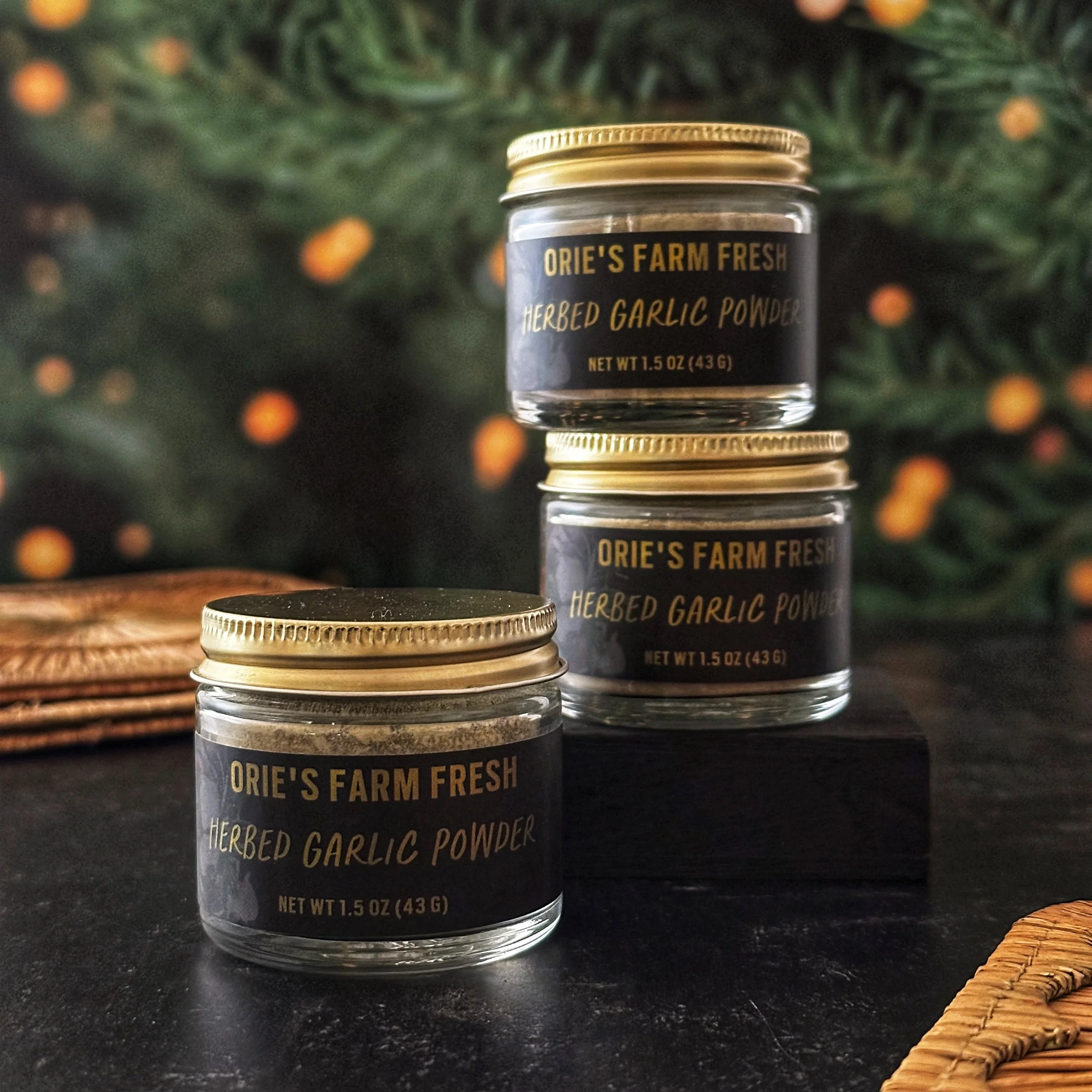 Herbed Garlic Powder jars are stacked in the center of the frame atop a slate surface.