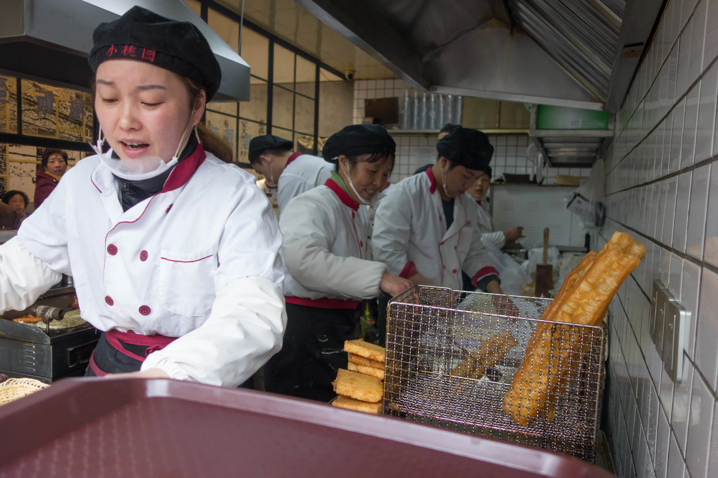 Eleven workers were busy in this tiny space (小桃园) preparing breakfast for a line of people that snaked out the door. Youtiao (油条) and shaobin (燒餅) were the main attractions
