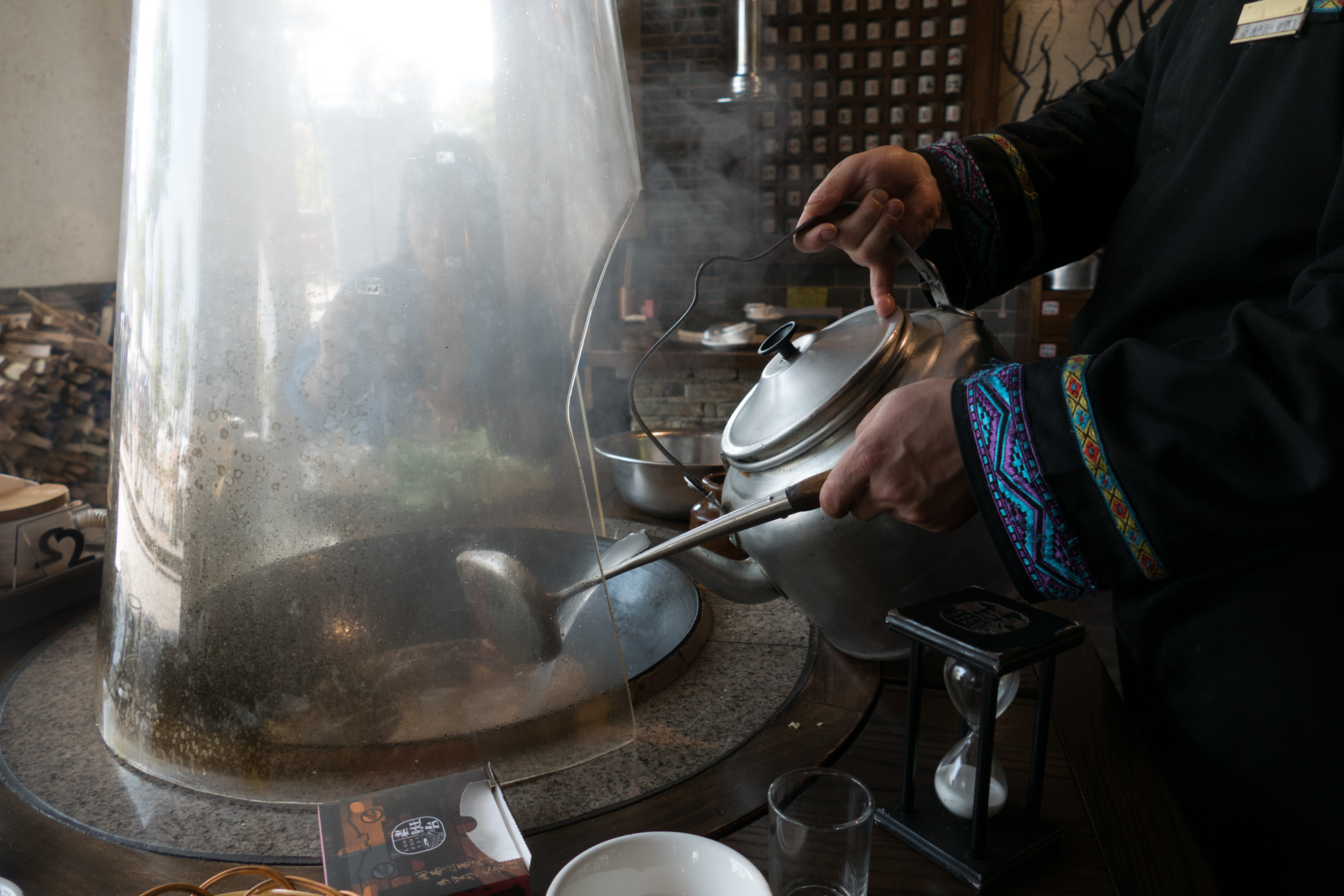 The wok is a wood burning stove and above the plastic hood is an attachment to an exhaust fan. After you sit down, the first thing they do is to stoke the fire with some wood. We had fish chowder, where they stir fry fresh fish, which can be seen in the pan, and seasonings and then add water to make a broth that cooks for 10 minutes