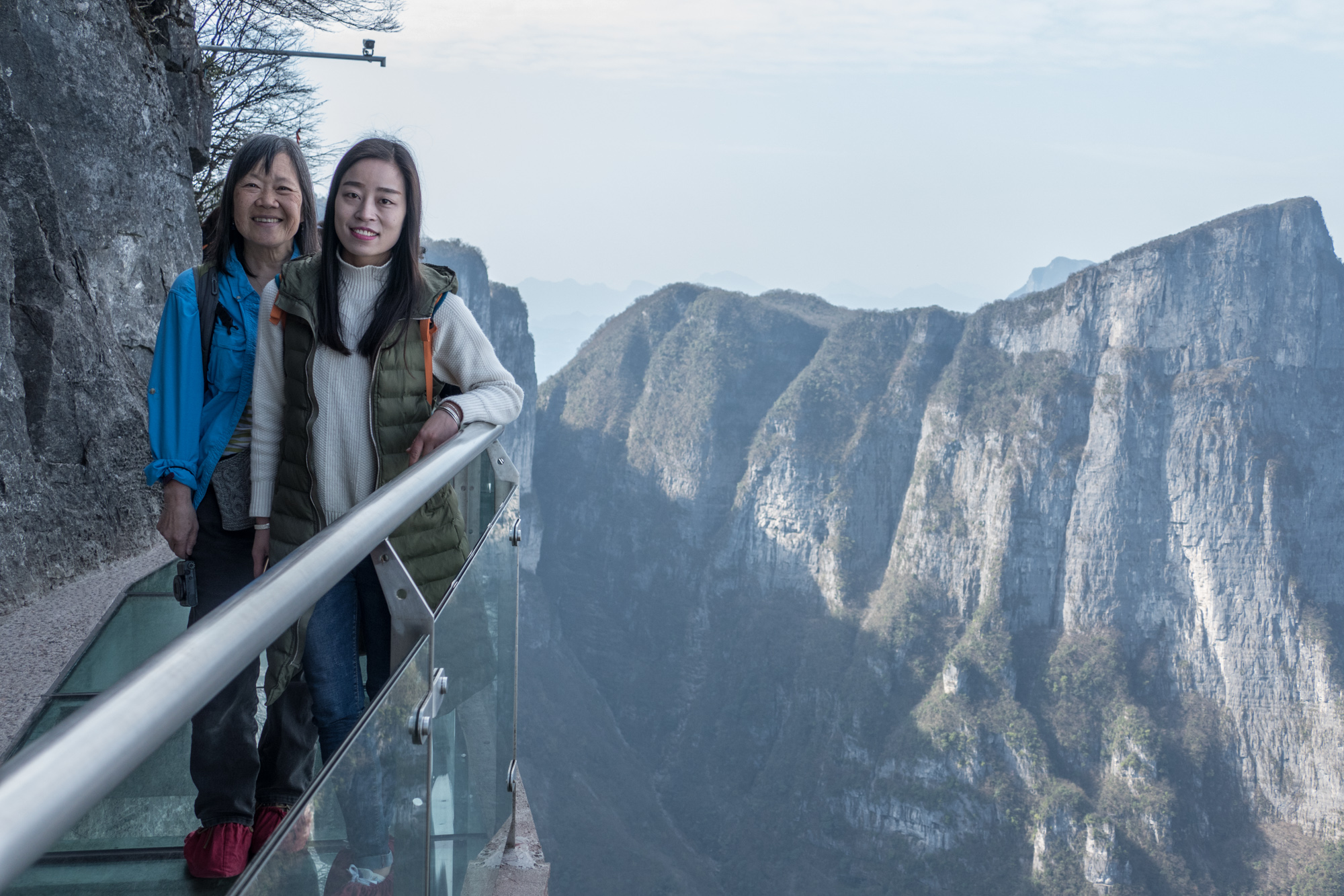 Lil and Summer on the glass cliff walk. Note the red rubber slippers that one has to wear on the walk to minimize scratching the glass.