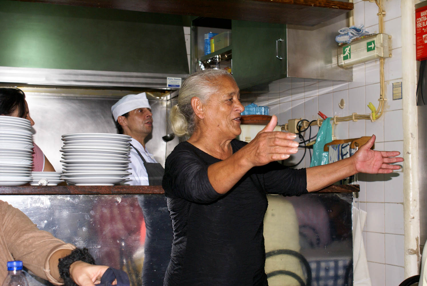 The owner of the small restaurant singing along to the fado singer