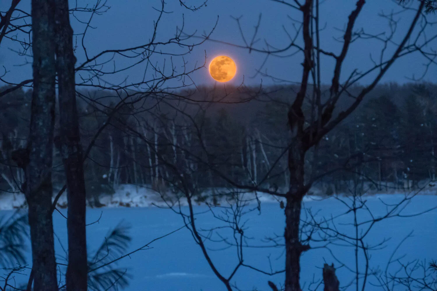 Rising full moon  over snow-covered lake.  This photo is a composite, made from two exposures over 7 stops different because of the brightness of the moon.