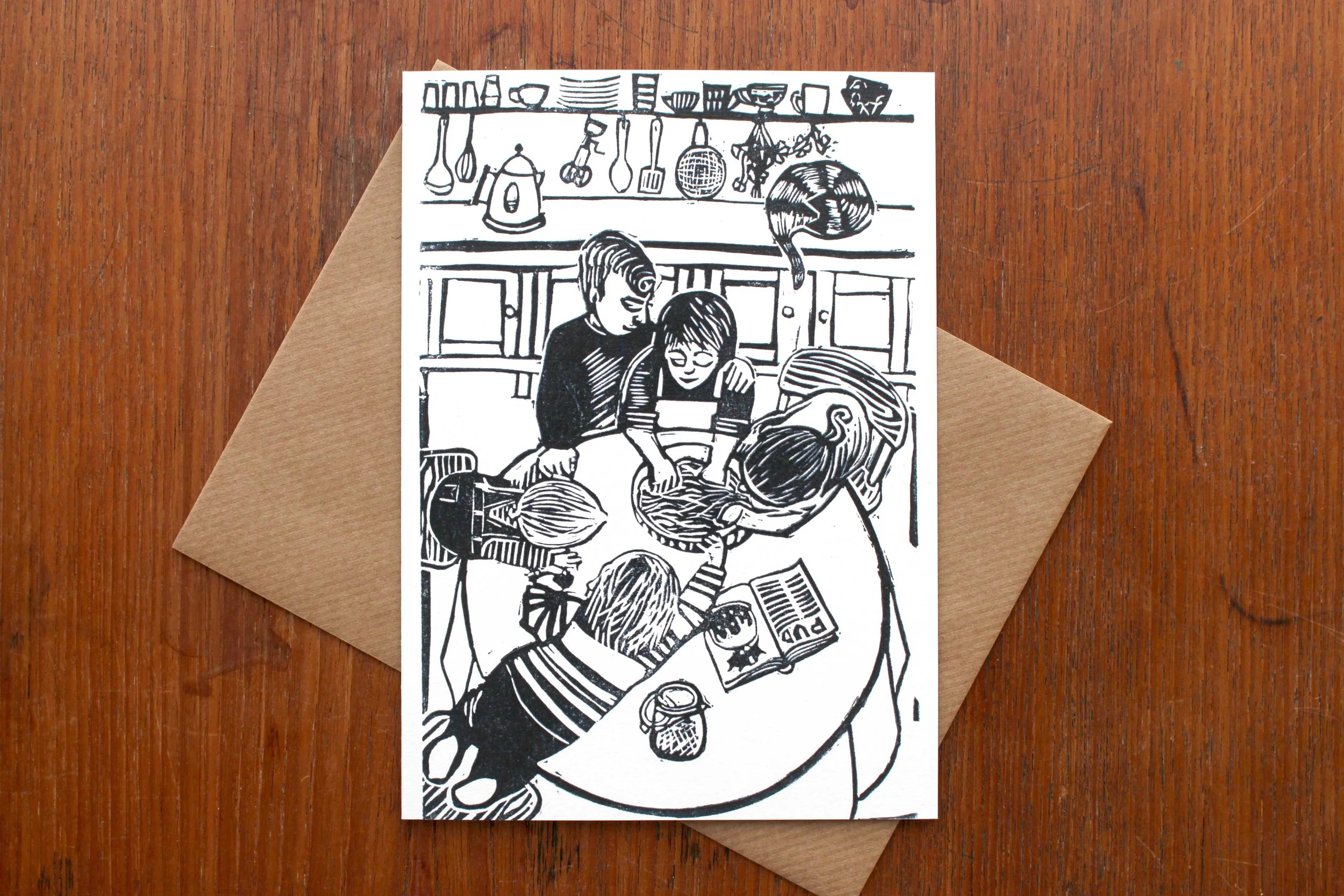 Stir Up Sunday linocut greeting card Cat Moore single block print Christmas pudding family domestic kitchen cat mixing children love black and white