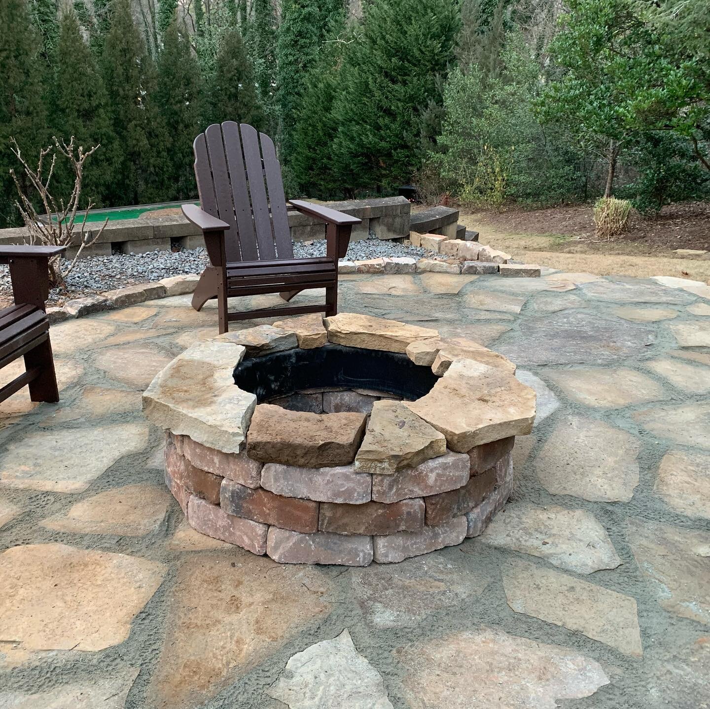 Created an outdoor hardscape area with flagstone and a fire pit #landscape