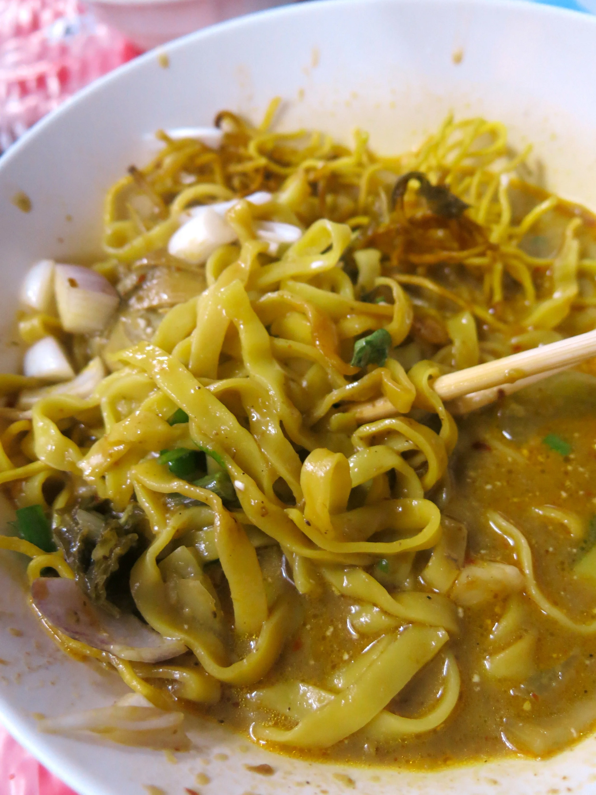 Khao Soi is eaten with both chop-sticks for the noodles and a large spoon for the broth