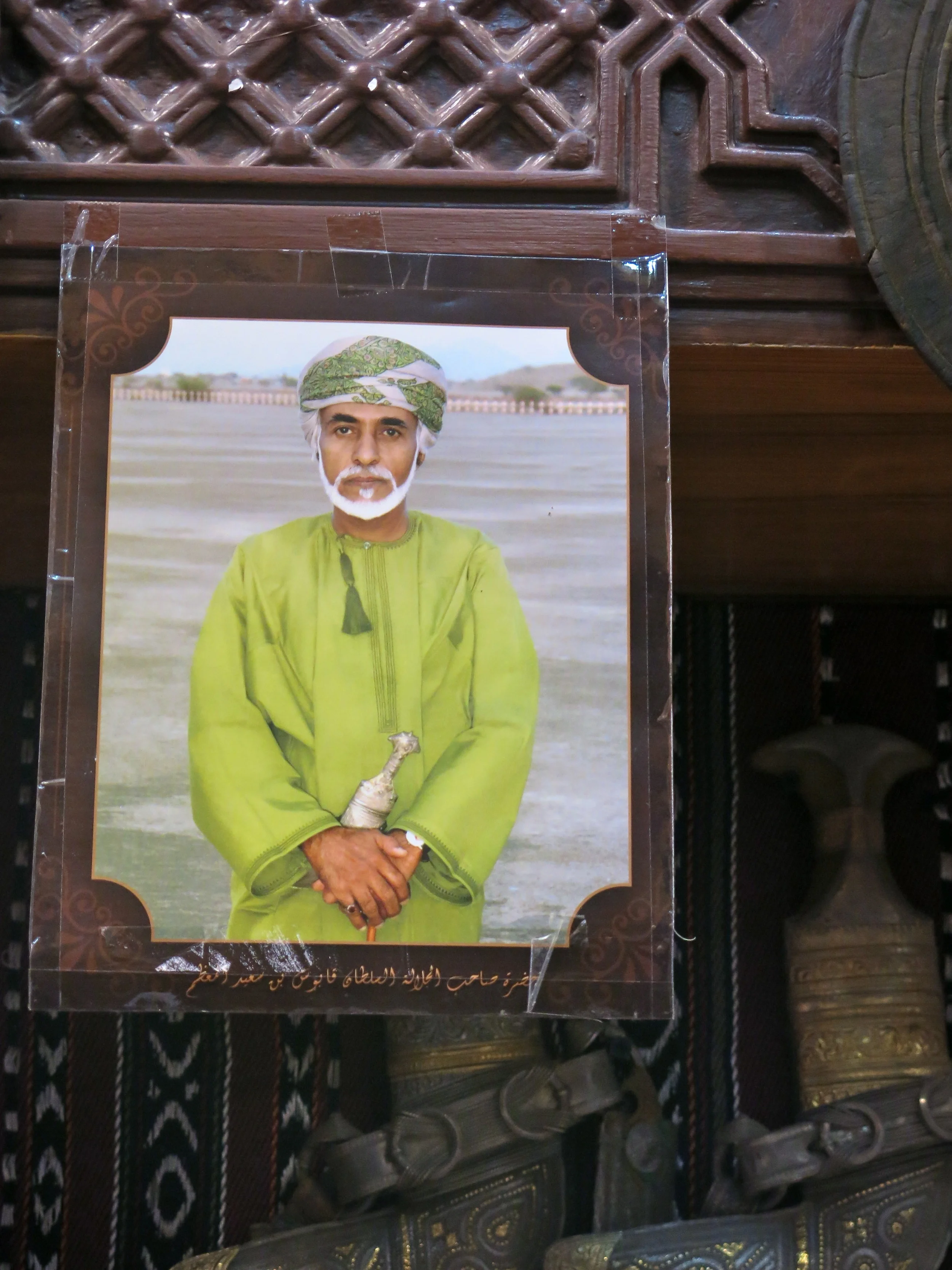 A portrait of Sultan Qaboos hanging in a souk