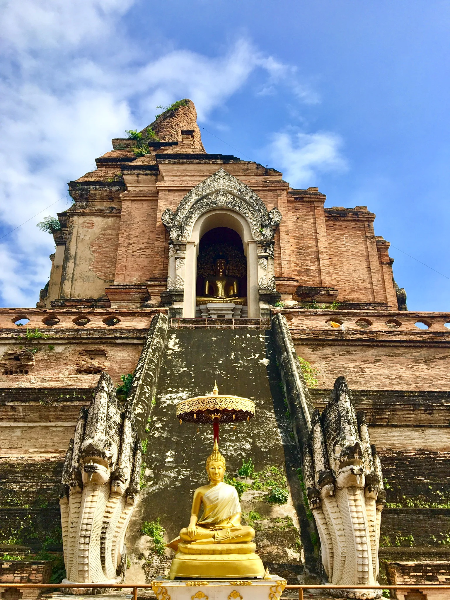 Golden Buddha surrounded by nagas guarding the steps