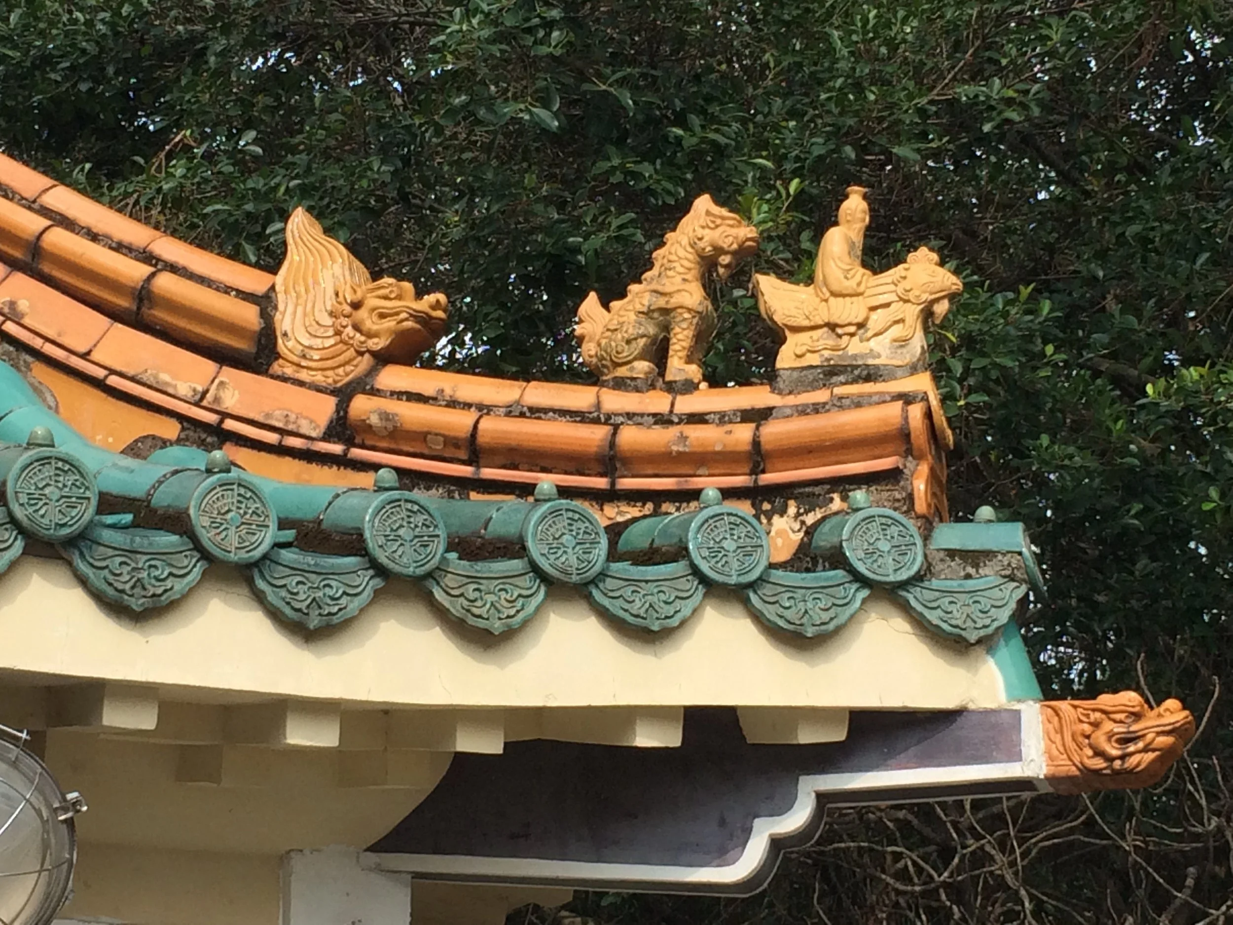 Closer look at man riding a phoenix-rooster on a gatehouse at the National Palace Museum