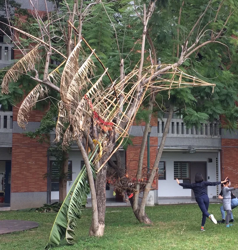 Enormous Bird takes flight from the dying tree, constructed with found bamboo and banana fronds