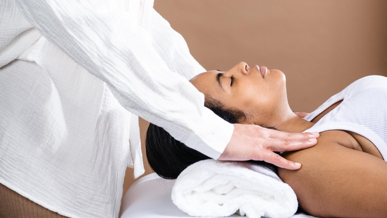 Woman receiving a neck and shoulder massage while lying on a spa treatment table