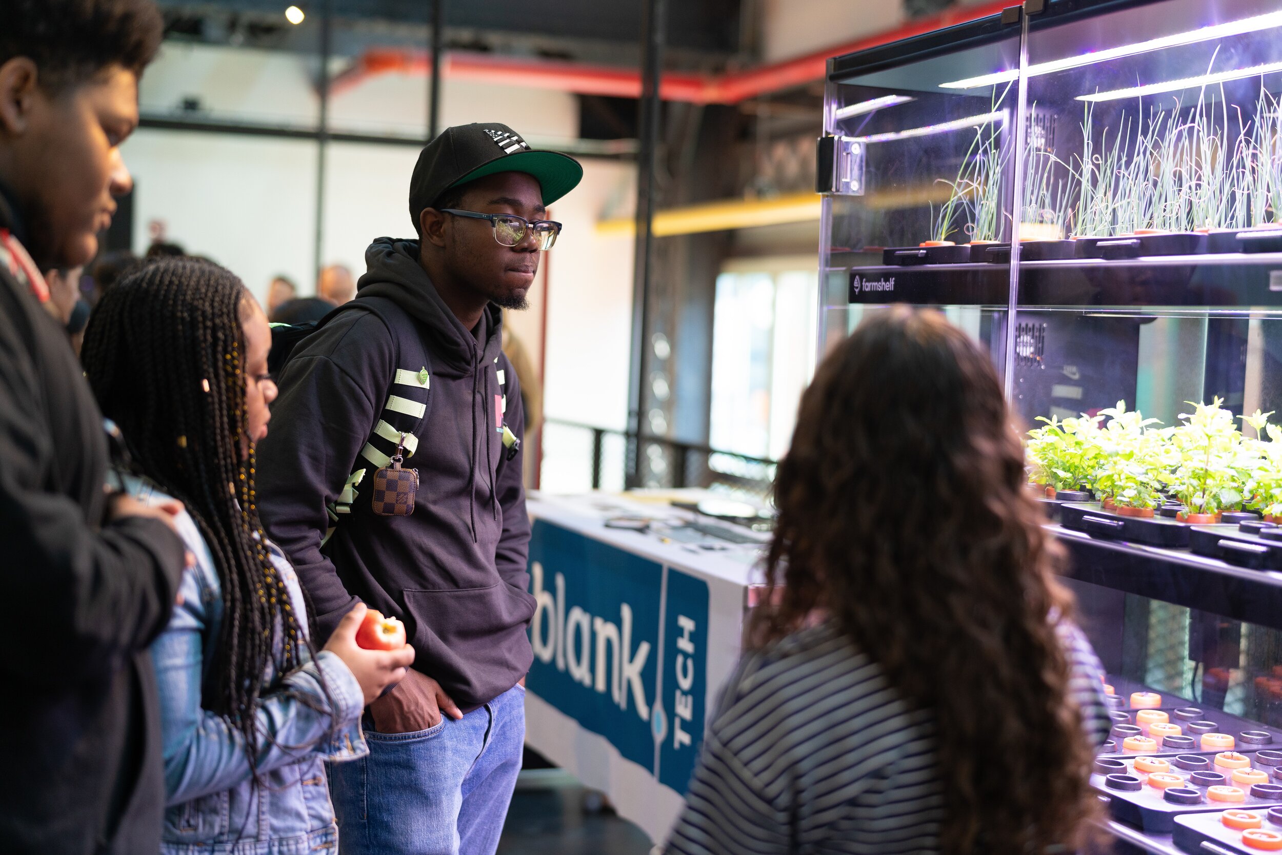   Students watch a hydroponics demonstration at New Lab's HE3AT launch event.&nbsp;  