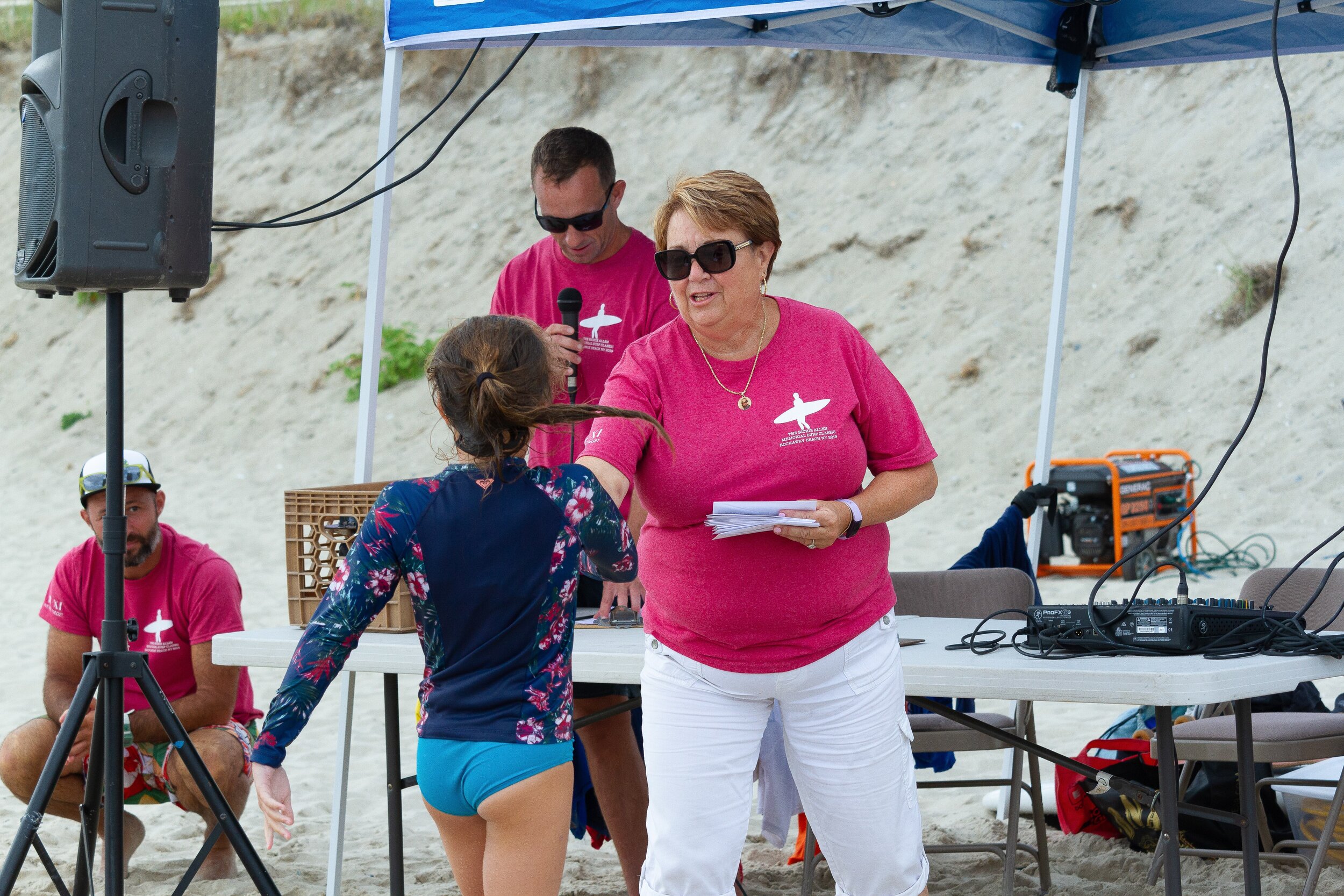   Gail Allen, Richie's mother, hands out cash prizes to the winners of the surf competition.&nbsp;  