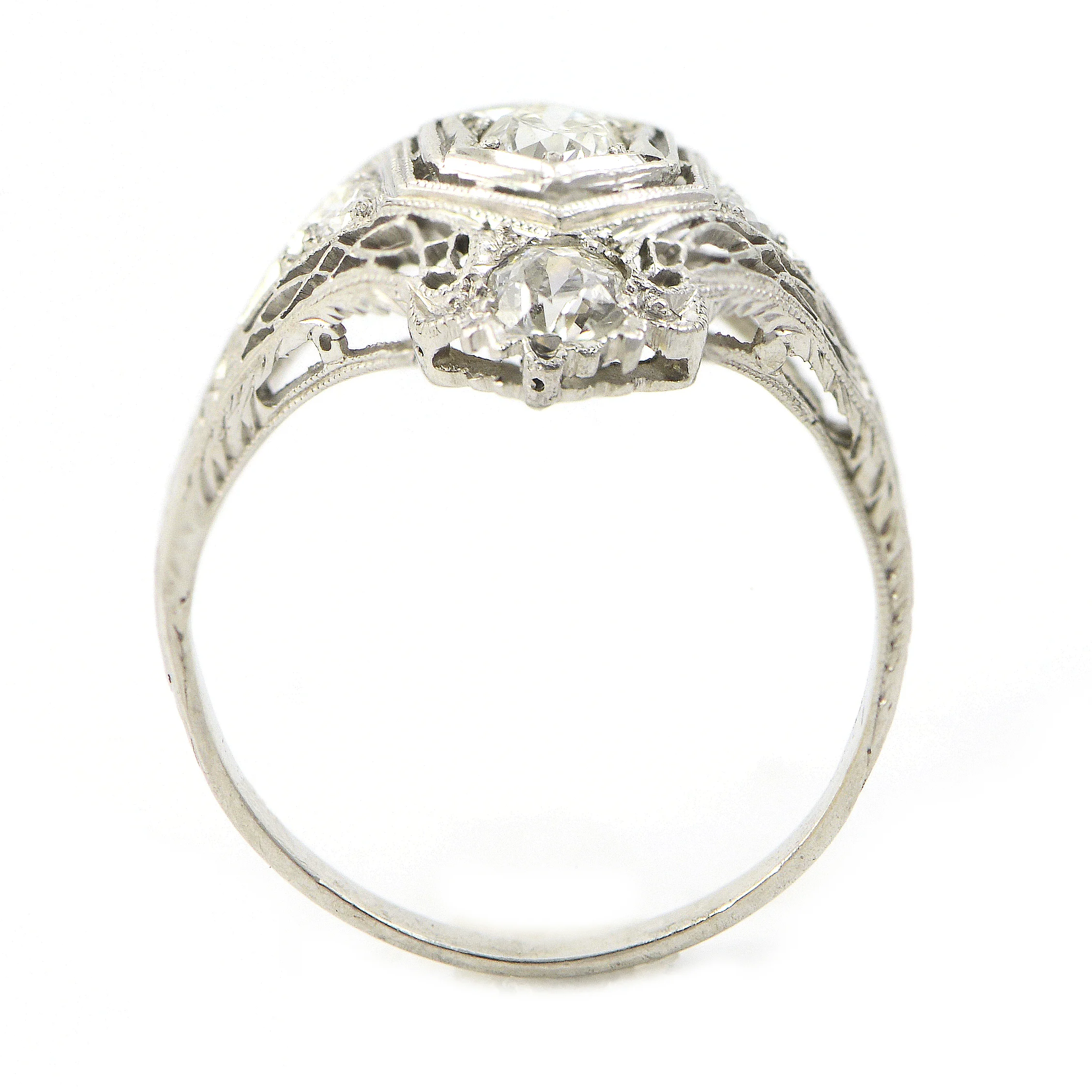 Platinum diamond ring with lattice style detailing. The ring has a center diamond, and one on each end. $6,550.00
