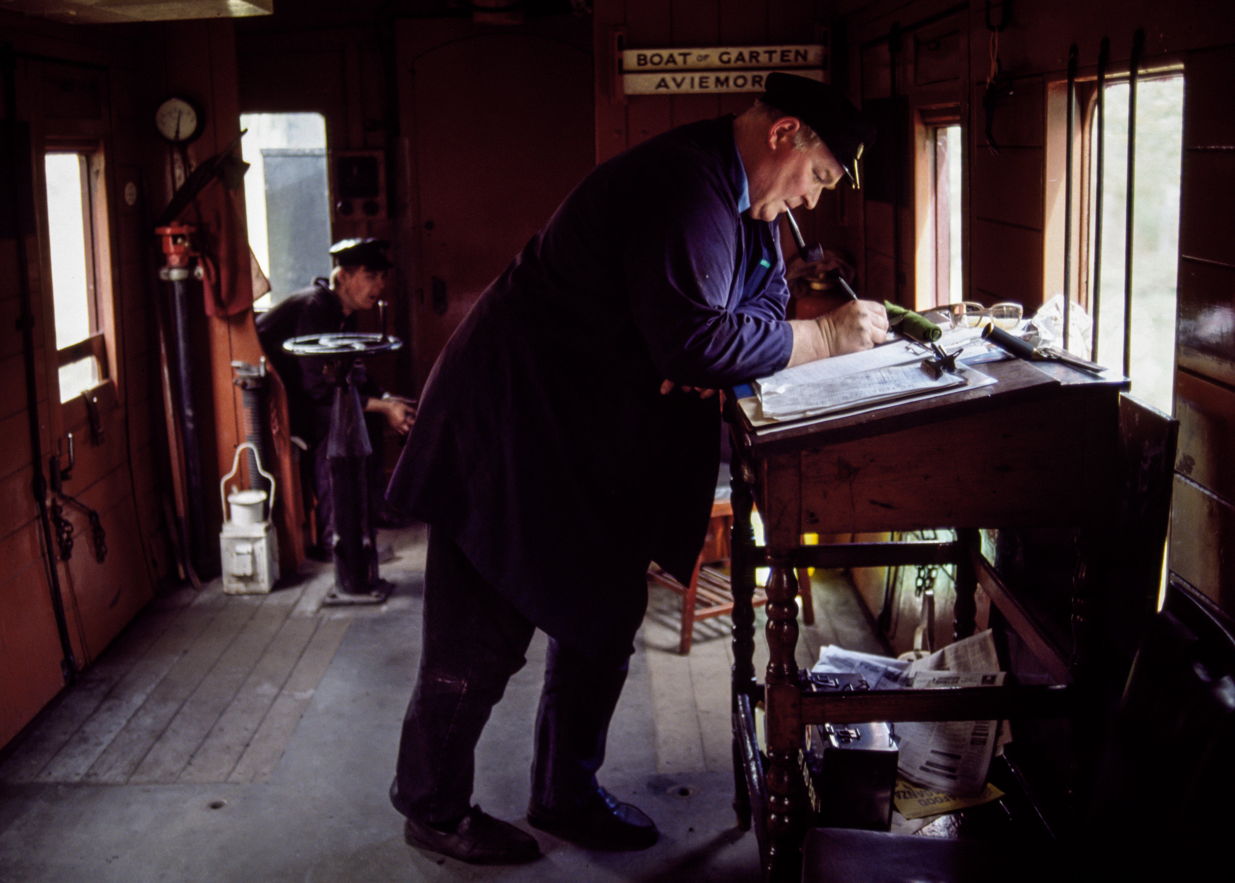 A Strathspey Railway conductor goes over his consist in the caboose en route from Boat of Garden to Avimore in Scotland