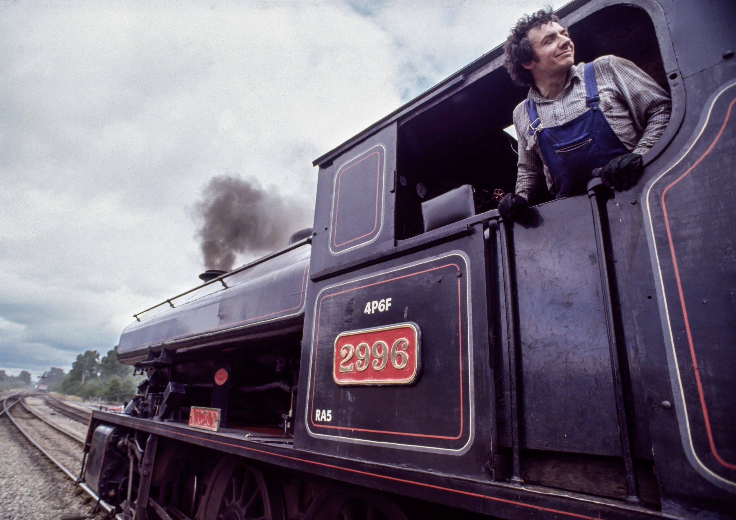 A ﬁreman looks back as a Strathspey Railway train leaves the station in Aviemore, Scotland