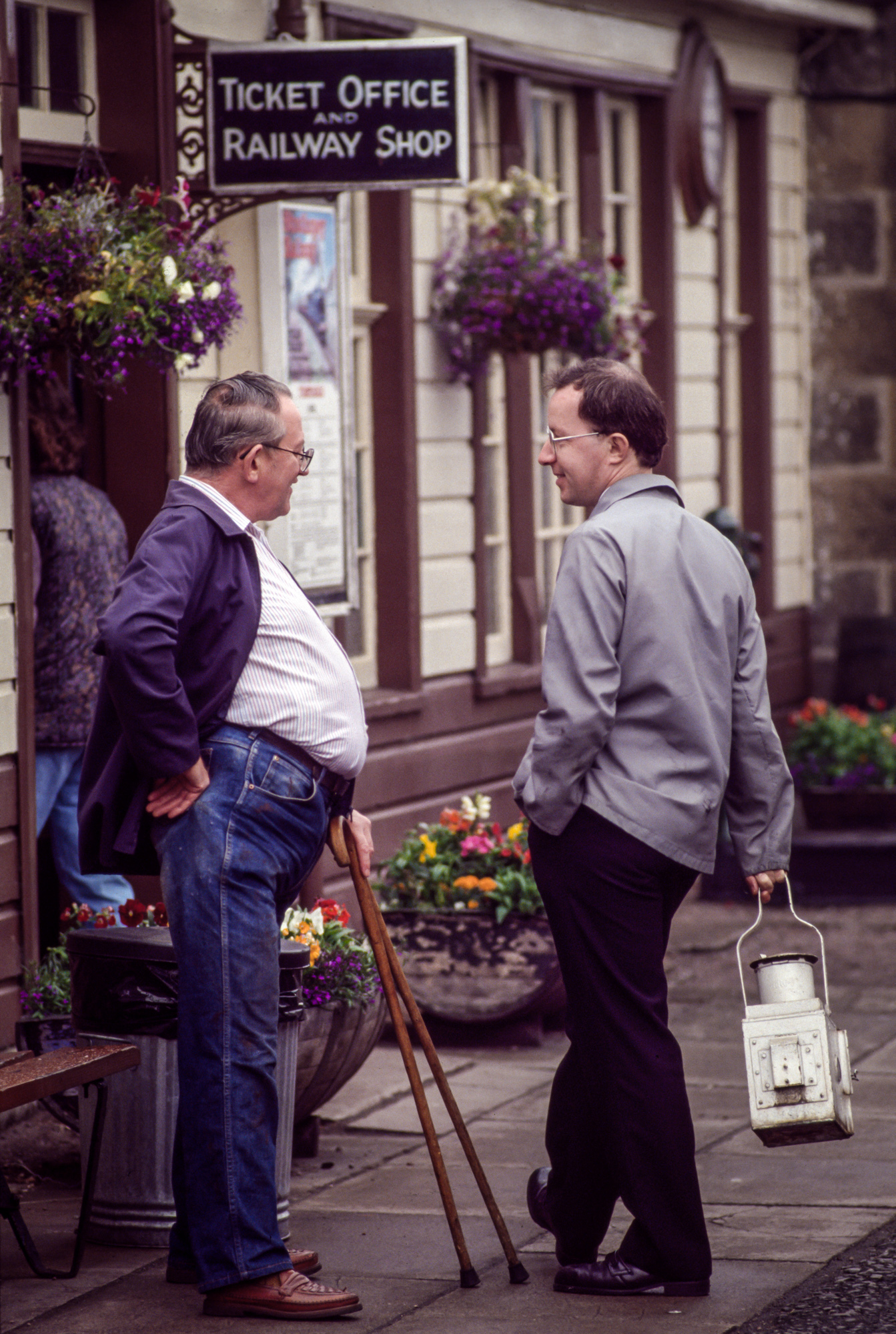 A ticket salesman and conductor talk outside the Strathspey Railway station in Aviemore, Scotland