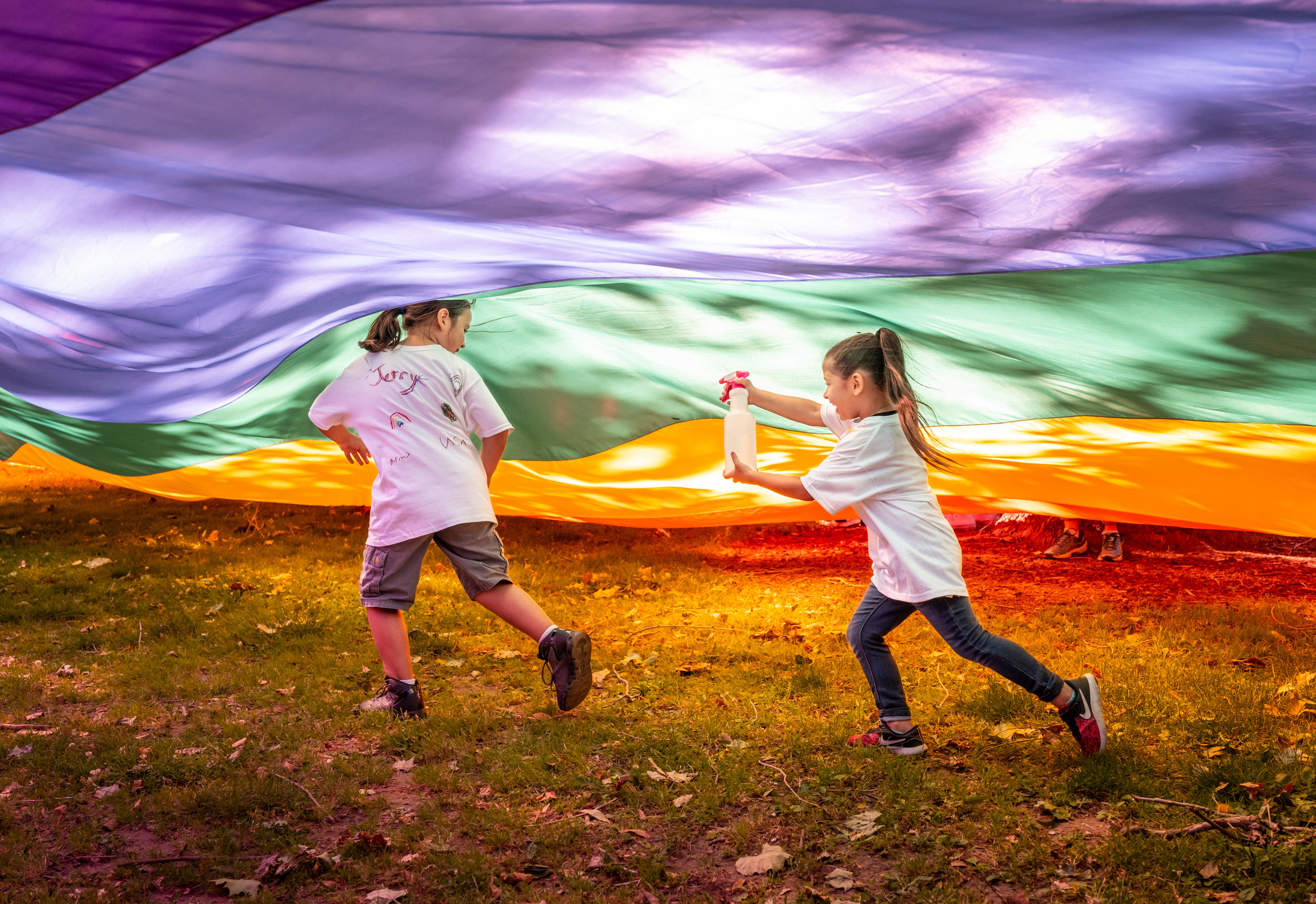 Children playing under a giant pride flag during the annual pride march in Sacramento, California