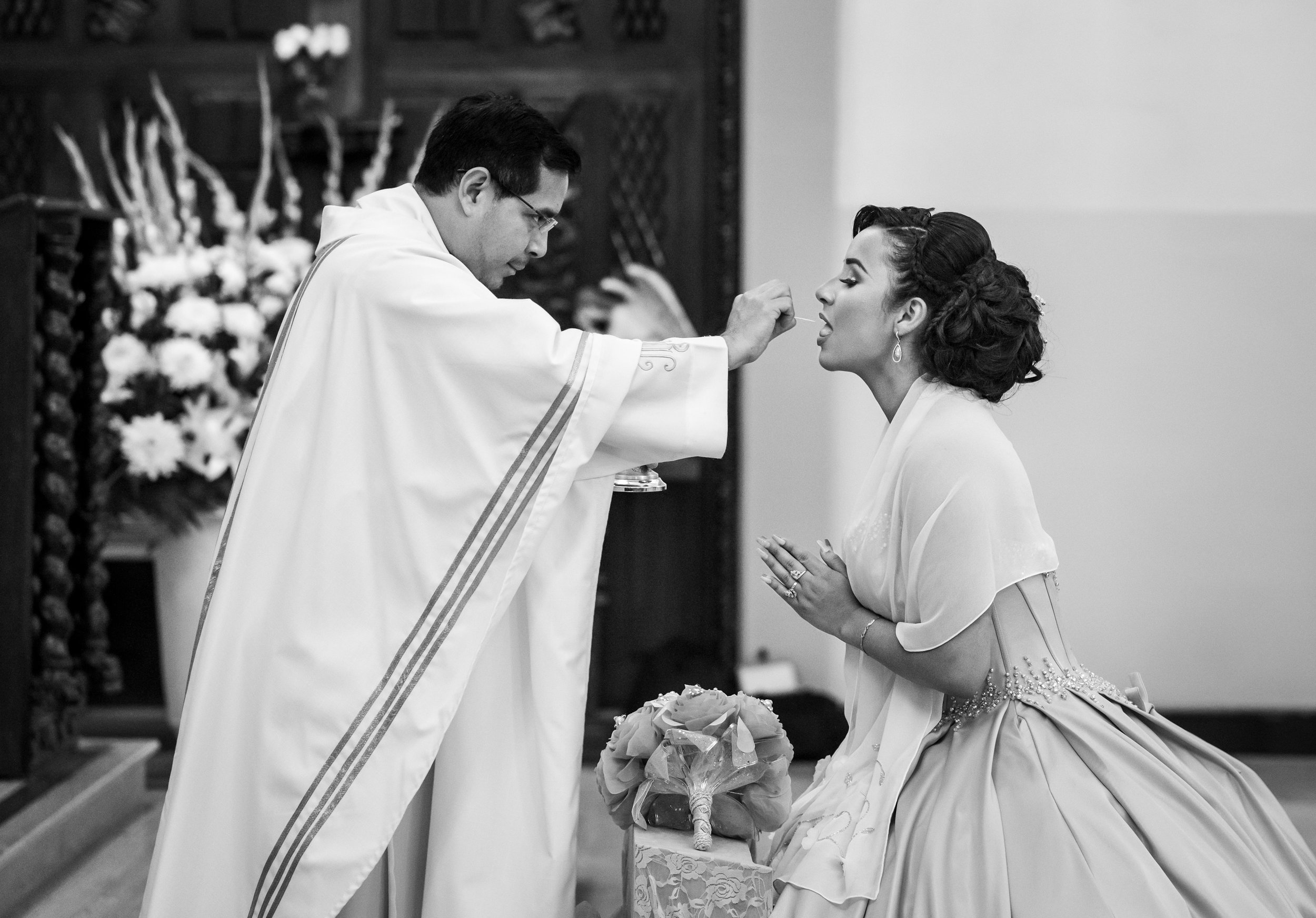 Adriana Gonzalez receiving communion from Father Edgardo Rodriguez during Adriana’s quinceañera at Our Lady of Guadalupe Church in Sacramento, California