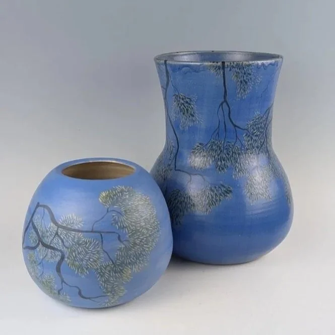 'Holding the sky'- vessel 1 (foreground)

Hand-thrown and fired by Nicci Parry Jones, with hand-applied glaze and sgraffito by Bronwyn Davies.

A finely drawn canopy moves across a luminous blue ground, extending Davies’ drawing practice into clay.

