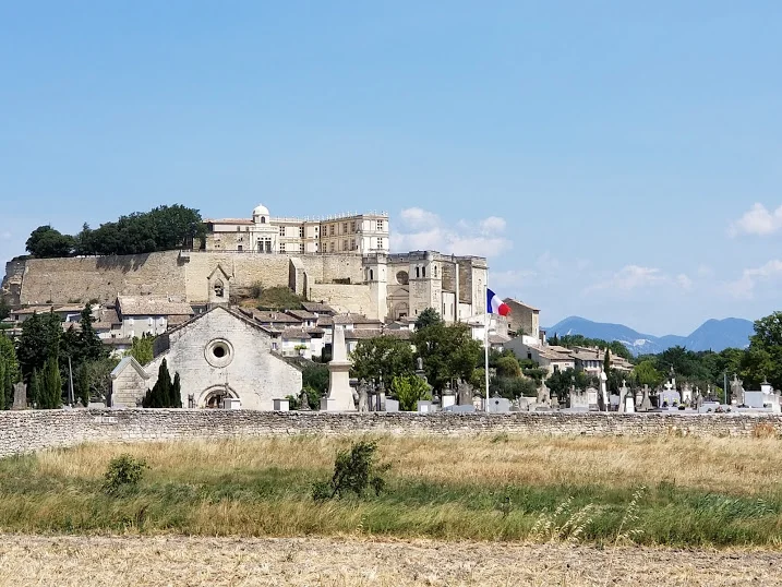 Grignan Castle in the distance beyond the cemetery