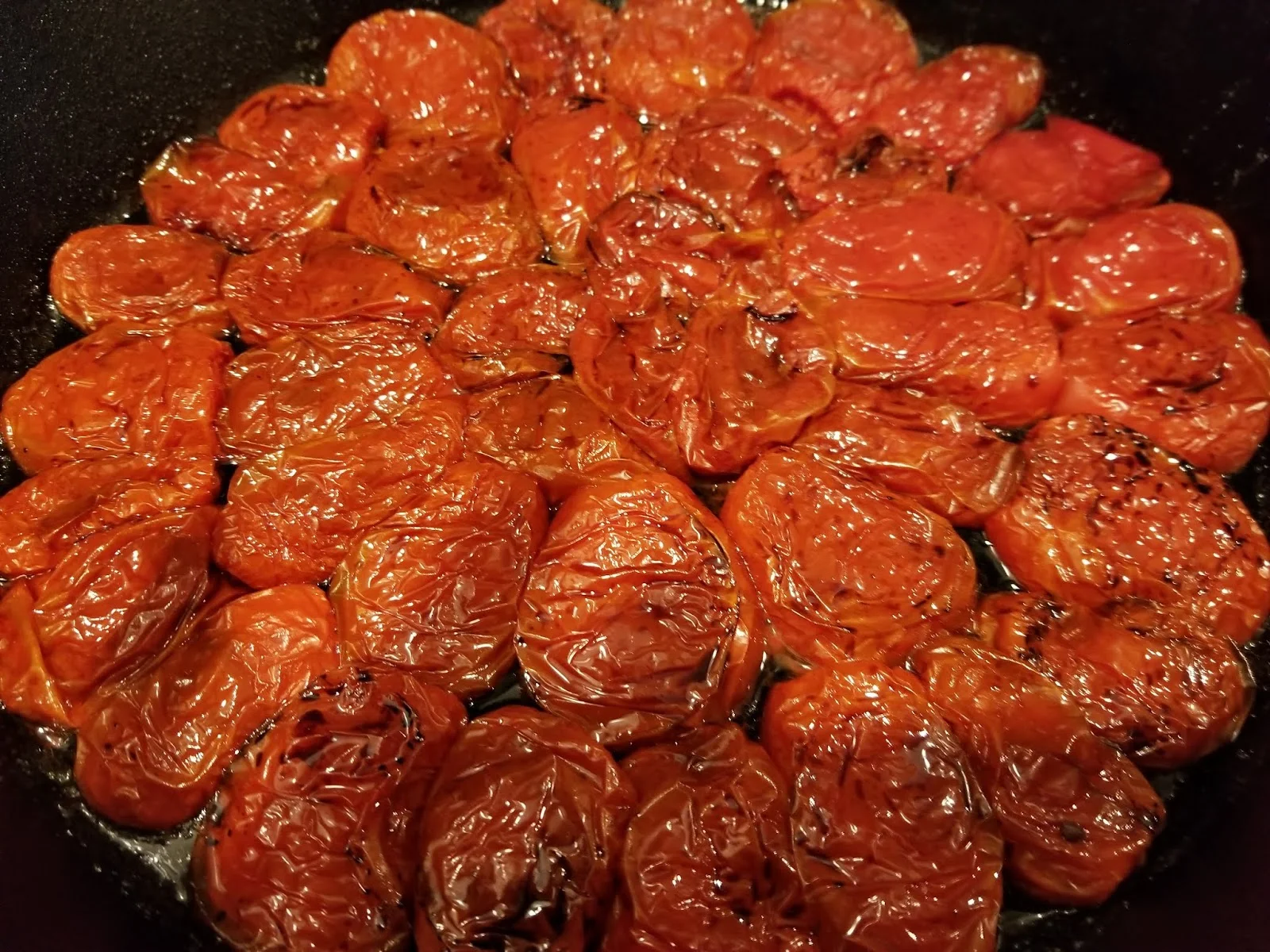 Oven roasted tomatoes arranged in 12 inch cast iron pan